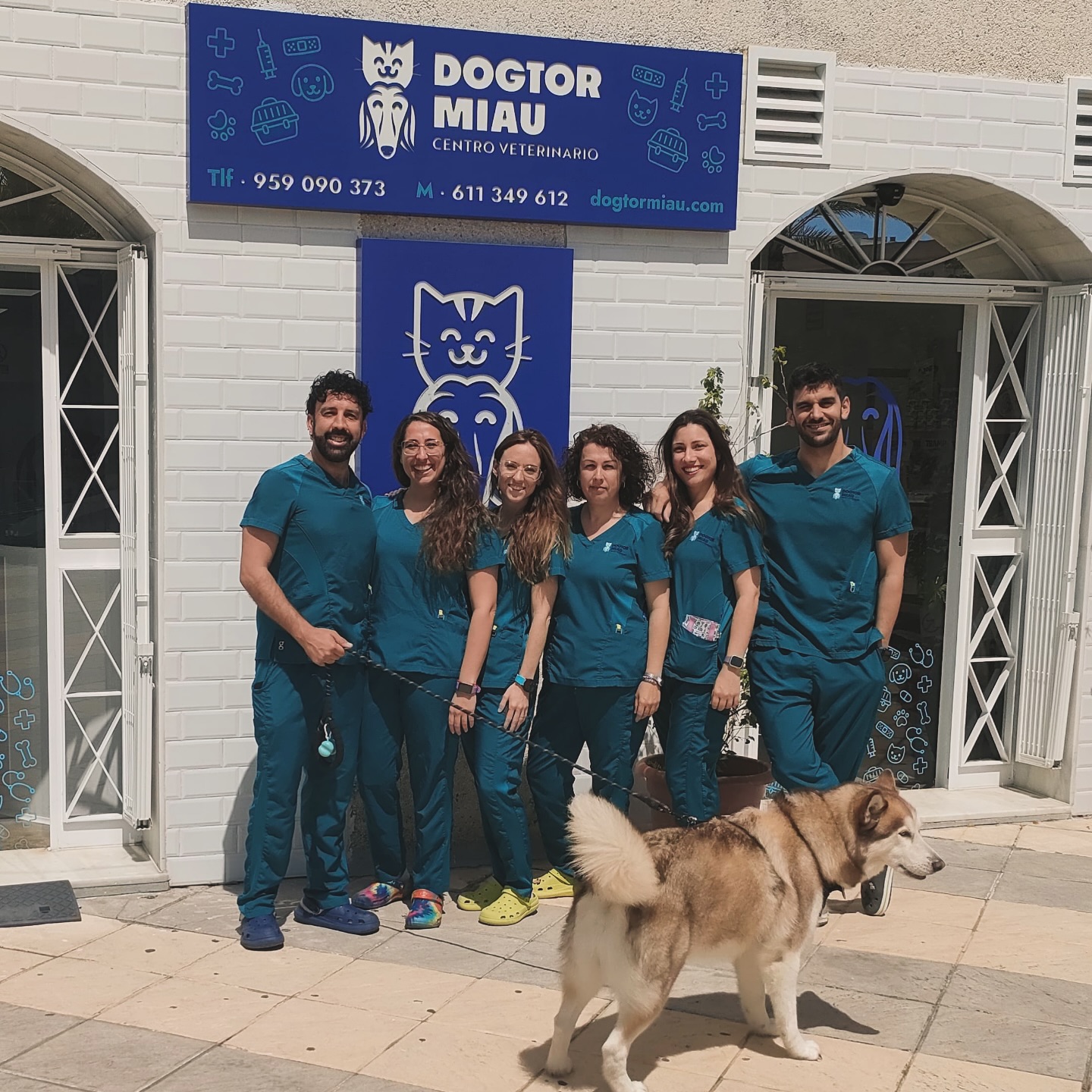 Equipo de DogtorMiau junto a un perro frente al centro veterinario